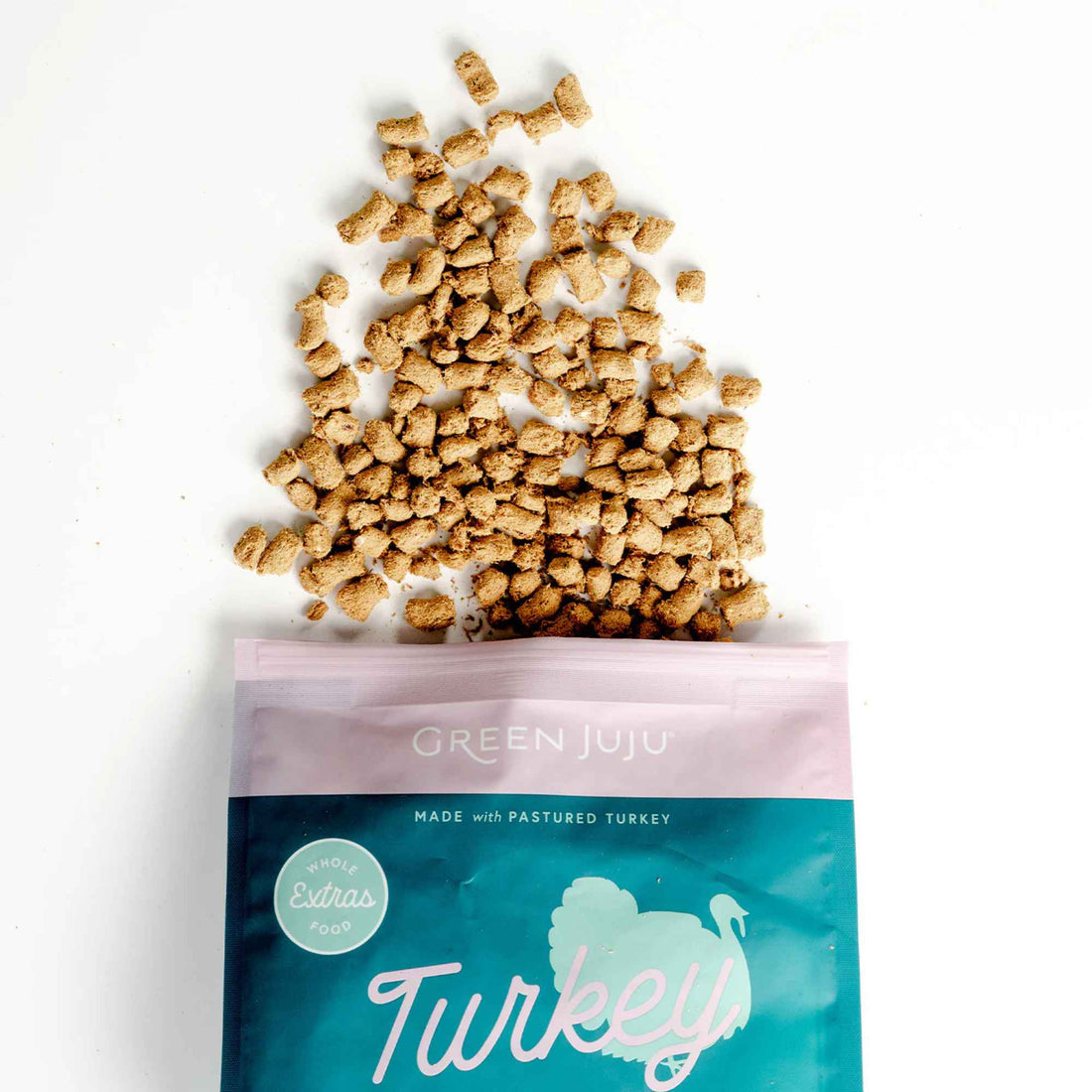 Green Juju turkey & sardine recipe pet food packaging with spilled food on a white background